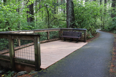 Viewpoint from wood deck with bench and railings off the paved route